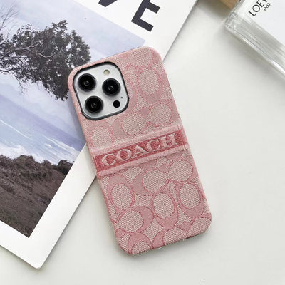 Holding Coach Ladies' iPhone Case to show texture