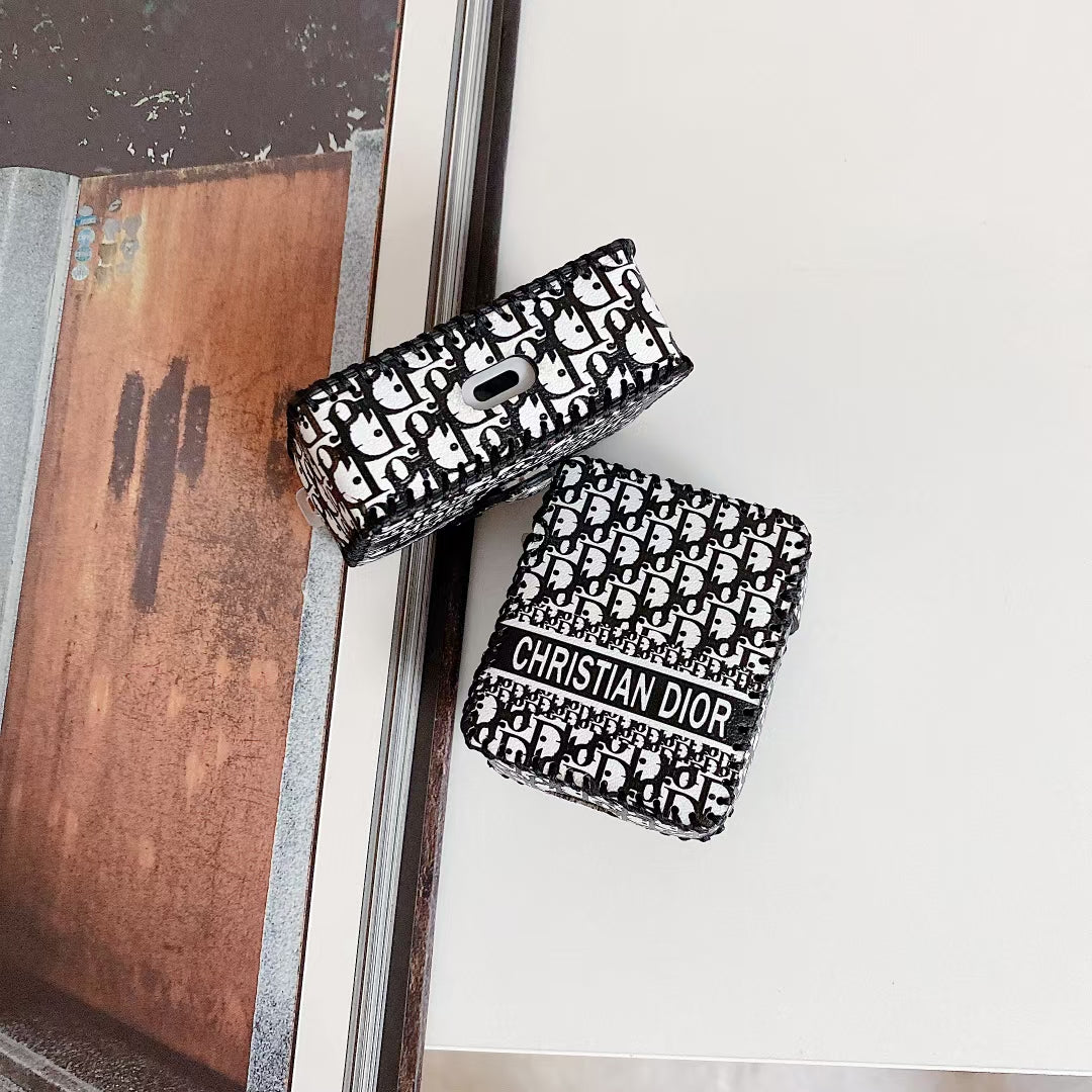 Elegant Dior Premier Chic AirPods Case next to a pair of AirPods and a Dior gift box