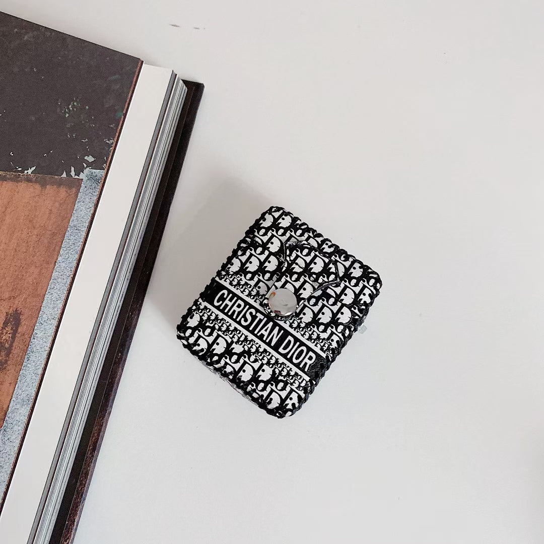 Dior Premier Chic AirPods Case displayed on a marble surface, highlighting its luxurious appeal