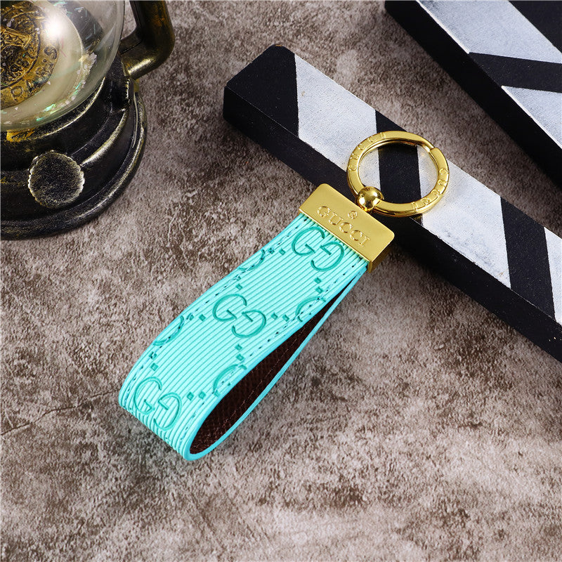 Gucci Keychain featuring the iconic logo and luxurious design, displayed against a neutral backdro