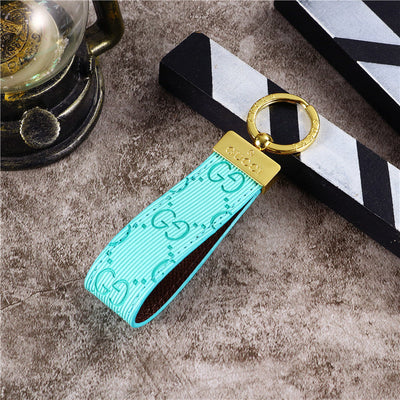 Gucci Keychain featuring the iconic logo and luxurious design, displayed against a neutral backdro